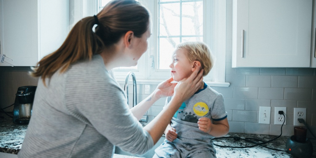 mum taking care of her son crying because of ear pain